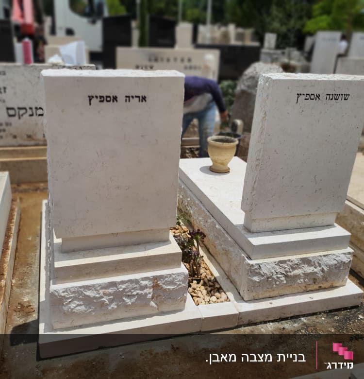 שני מצבות לבנות עם כיתוב בעברית בבית קברות